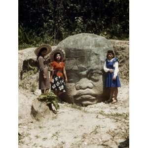  Three Women Stand Next to a Large Stone Face Photographic 